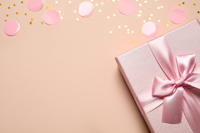 Pink gift box and confetti on color background, top view. Space for text