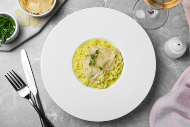Photo of Delicious risotto with cheese on grey marble table, flat lay