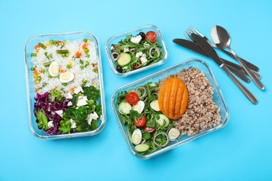 Set of glass containers with fresh food and cutlery on light blue background, flat lay