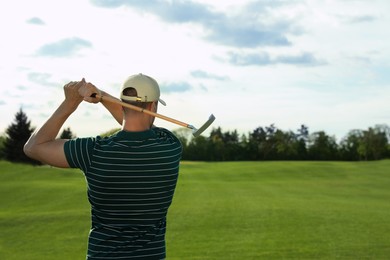 Man playing golf on green course, back view. Space for text