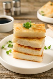 Delicious turnip cake with microgreens served on wooden table