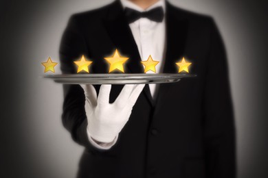 Five Star Luxury Hotel. Waiter with tray on grey background, closeup