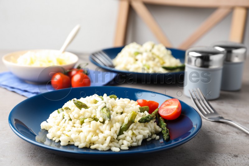 Delicious risotto with asparagus on grey table
