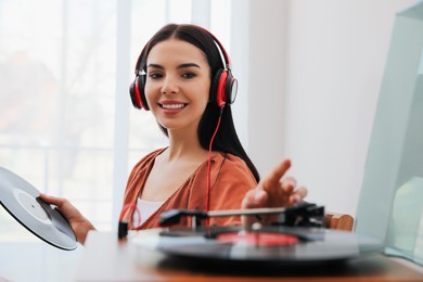 Woman listening to music with turntable at home