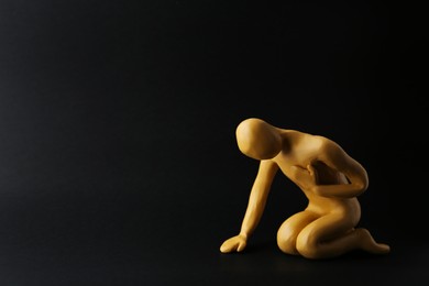 Plasticine figure of human asking help on black background. Space for text