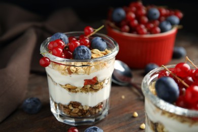 Delicious yogurt parfait with fresh berries on wooden table, closeup