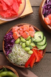 Photo of Delicious poke bowls with vegetables, fish and edamame beans on wooden table, flat lay