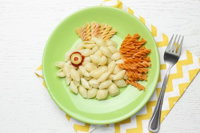 Tasty pasta served on white wooden table, flat lay. Creative idea for kid lunch