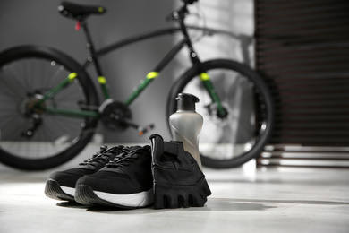 Bicycle gloves, shoes and bottle on floor 