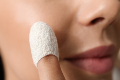 Photo of Woman using silkworm cocoon in skin care routine, closeup
