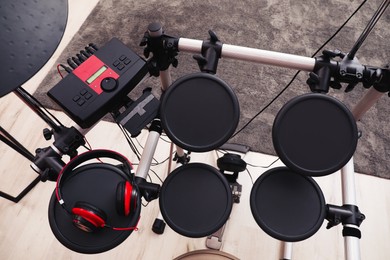 Modern electronic drum kit with headphones indoors, above view. Musical instrument
