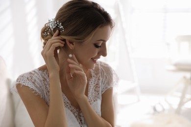 Young bride with elegant wedding hairstyle in room