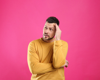 Emotional man in casual outfit on pink background