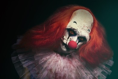 Terrifying clown on black background. Halloween party costume