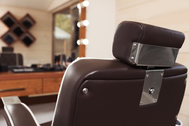 Photo of Stylish hairdresser's workplace with professional armchair in barbershop, closeup