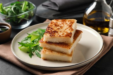 Delicious turnip cake with arugula served on black table