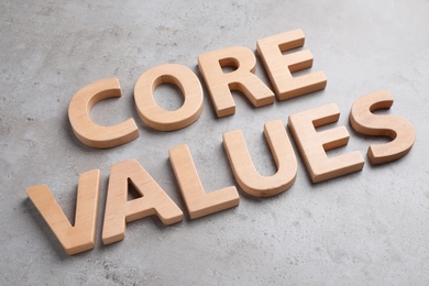 Photo of Phrase CORE VALUES made with wooden letters on grey background