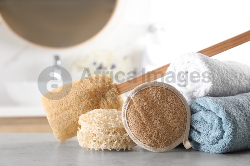 Natural loofah sponges and towels on table in bathroom
