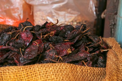 Heap of Ancho chile peppers on counter at market, closeup