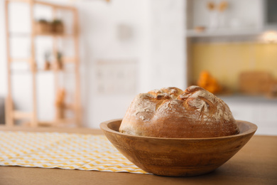Bowl with fresh bread on table in kitchen