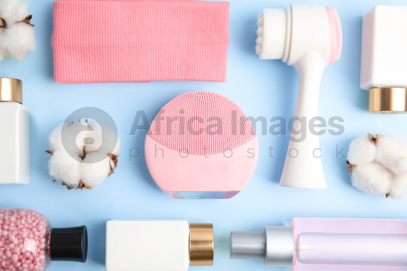 Photo of Flat lay composition with face cleansing brushes on light blue background. Cosmetic tools