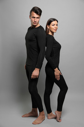 Couple wearing thermal underwear on grey background