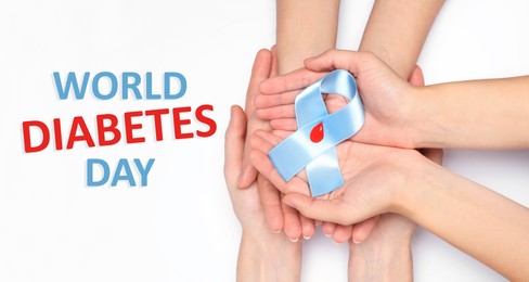 World Diabetes Day. People holding light blue ribbon with paper blood drop on white background, top view 