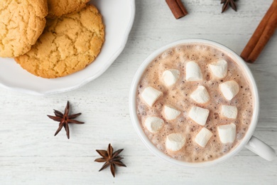 Composition with delicious hot cocoa drink and cookies on white wooden background, flat lay