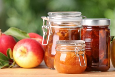Delicious apple jams and fresh fruits on wooden table