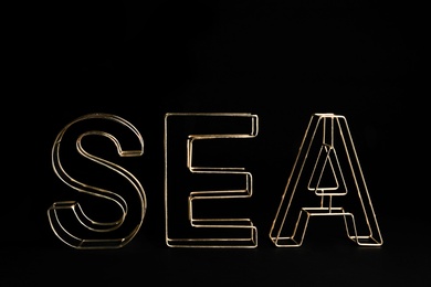 Word SEA of decorative gold letters on black background