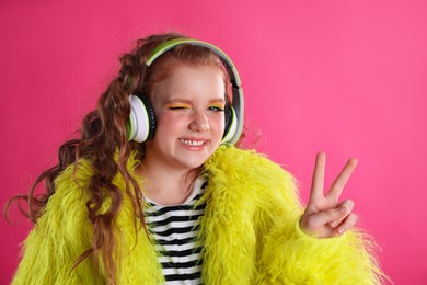 Cute indie girl with headphones on pink background
