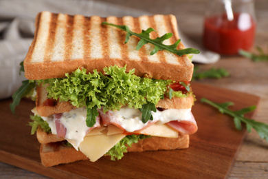 Photo of Yummy sandwich with ham served on wooden table, closeup