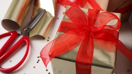 Beautifully wrapped gift box on white table, closeup