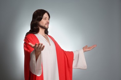 Jesus Christ with outstretched arms on light grey background