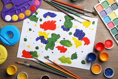 Flat lay composition with abstract child's painting on wooden table