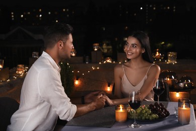 Romantic couple on cafe terrace at night