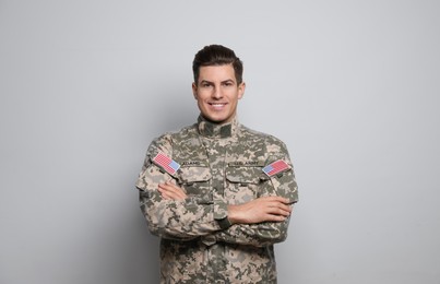 Portrait of happy cadet on light grey background