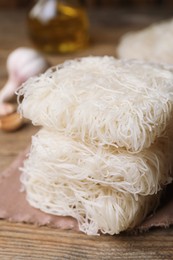 Photo of Uncooked rice noodles on wooden table, closeup