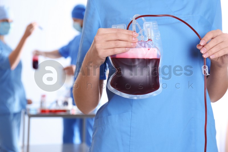 Photo of Doctor holding blood pack for transfusion at hospital, closeup. Donation day