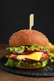 Photo of Delicious burger with beef patty and lettuce on wooden table