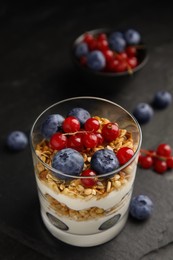 Delicious yogurt parfait with fresh berries on black table, closeup