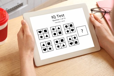 Woman using tablet for taking IQ test indoors, closeup