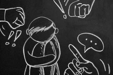 People bullying sad human drawn on blackboard