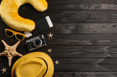 Flat lay composition with yellow travel pillow on wooden background, space for text