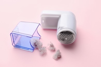 Photo of Fabric shaver with fuzz on pink background, closeup