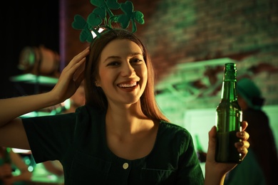Woman with beer celebrating St Patrick's day in pub