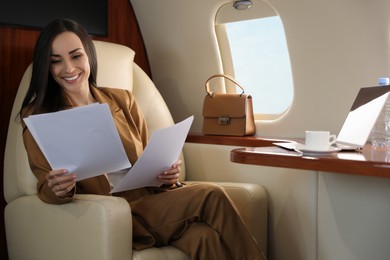 Businesswoman working with documents in airplane during flight