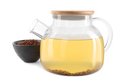 Photo of Glass teapot with aromatic buckwheat tea and granules on white background