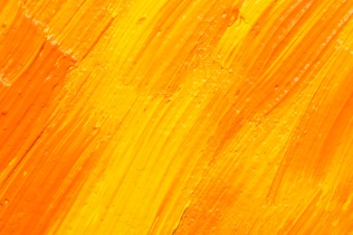 Beautiful strokes of yellow and orange oil paints as background, closeup