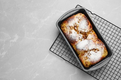 Photo of Delicious yeast dough cake in baking pan on marble table, top view. Space for text